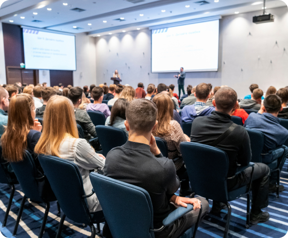 Salle de conférence avec participants et attentifs.