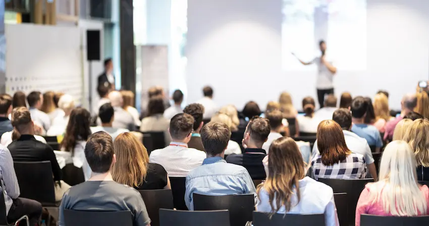 Salariés dans une grande salle lors d'un séminaire d'entreprise